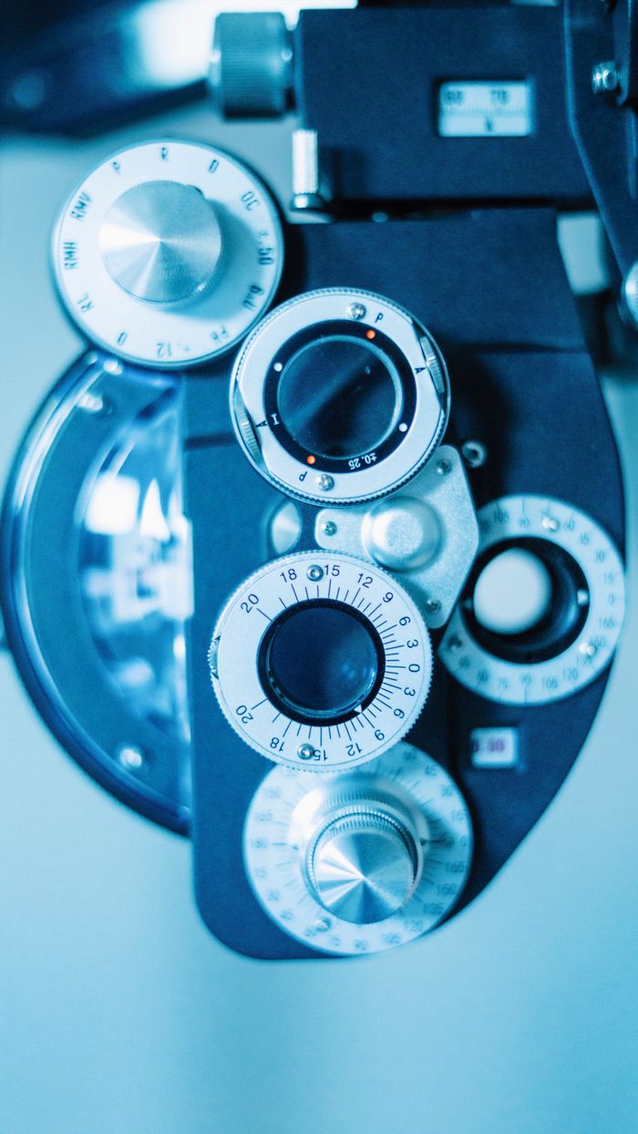 Detailed view of a phoropter used in eye examinations, showcasing precision dials and lenses.